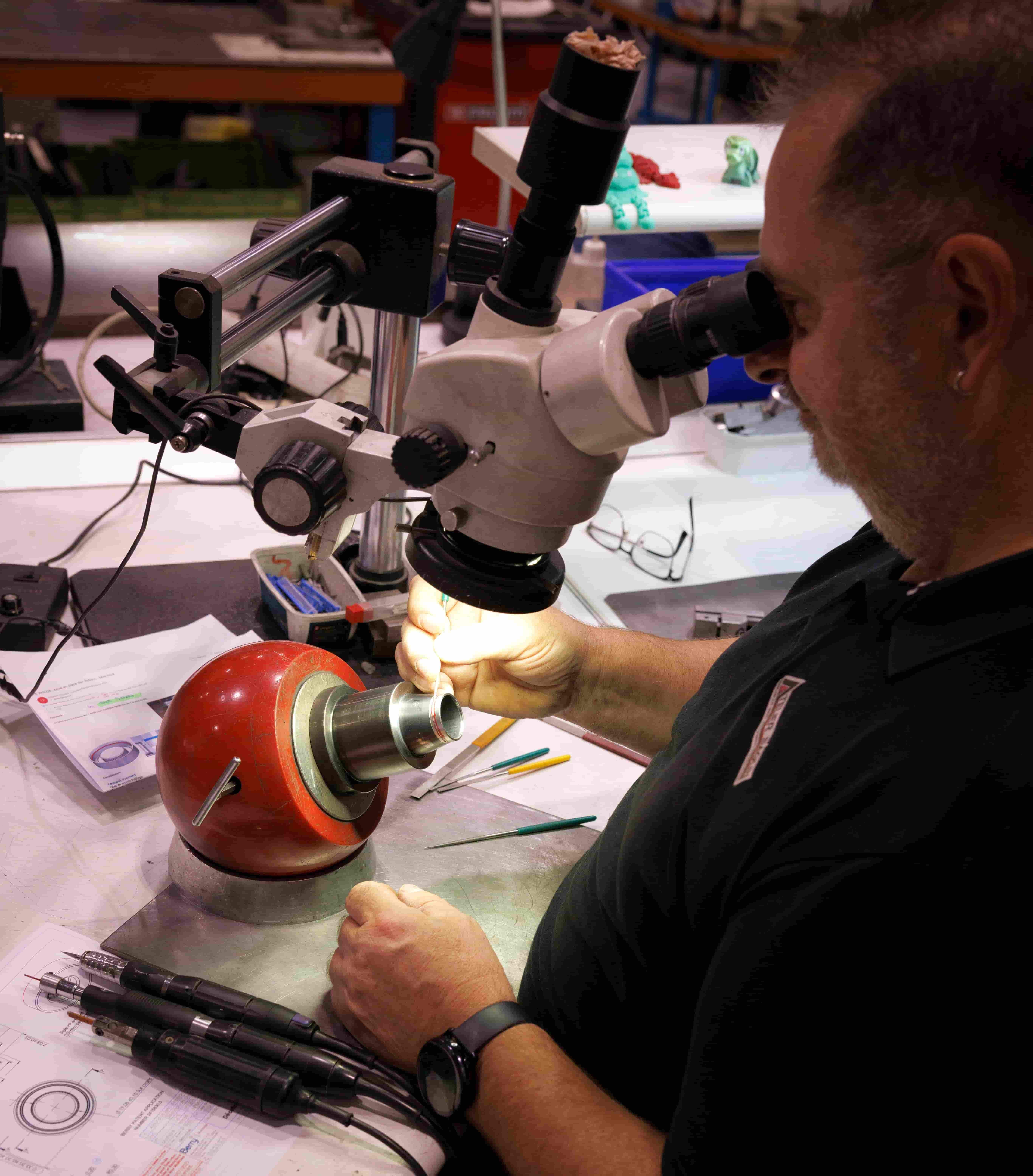 Opérateur réalisant un ajustage de précision sous microscope