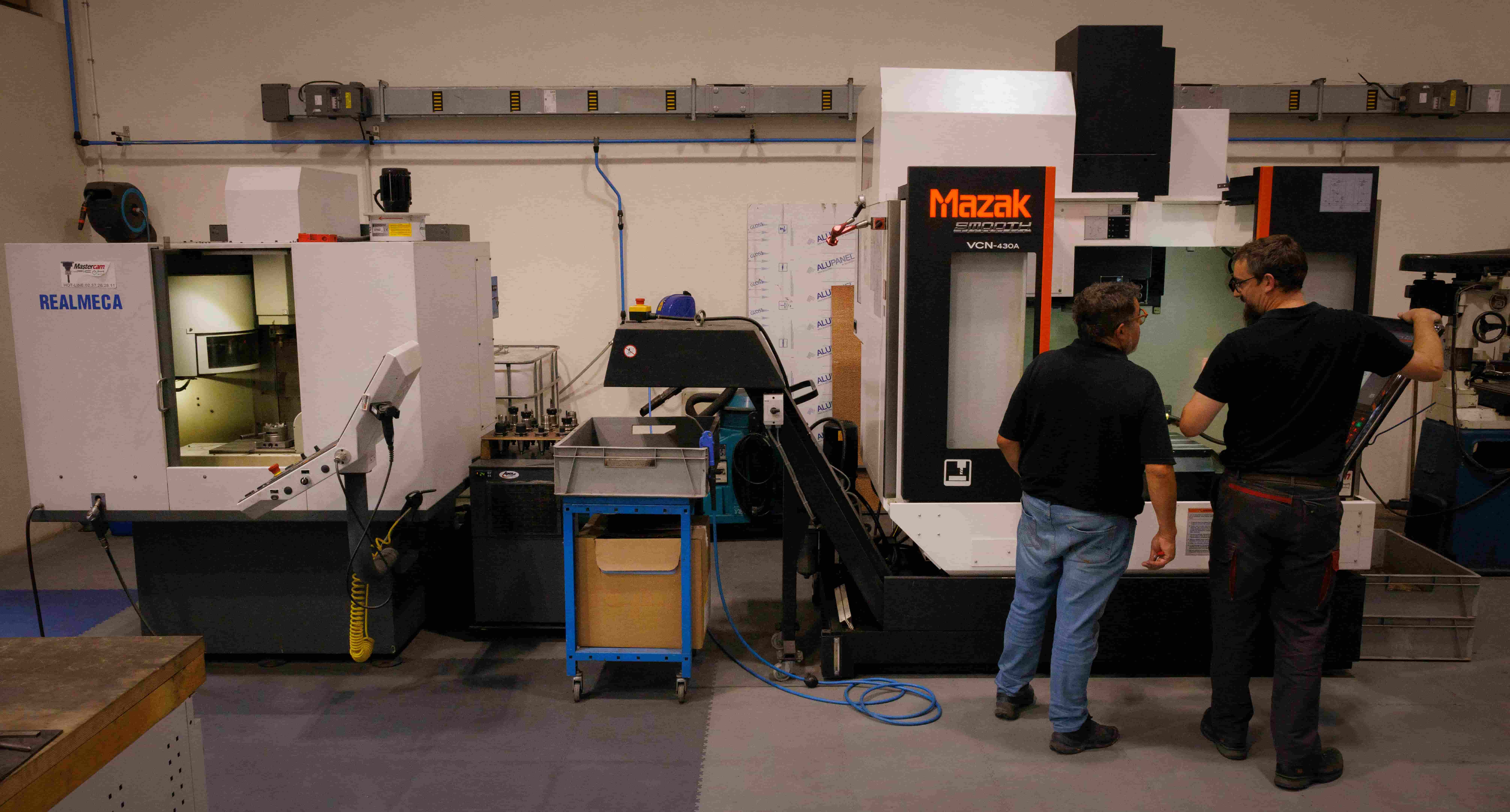 Centre d’usinage Mazak avec deux opérateurs vérifiant les réglages de la machine-outil